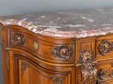a marble top on a wooden dresser in a room