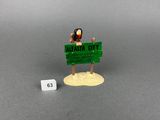 a small figurine of a woman holding a sign