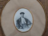 an old picture of a man with a hat and tie in a gold frame