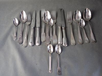 a lot of silver spoons and forks laid out on a table