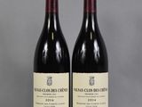two bottles of red wine sitting on top of a table