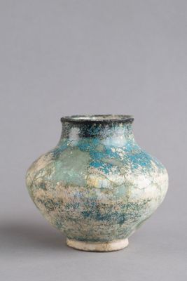 une image représentant un vase bleu et vert sur fond gris