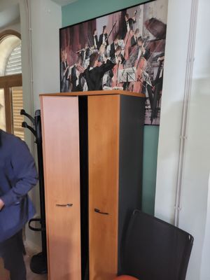 a man that is standing next to a cabinet in a room