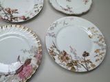 three plates with floral designs are sitting on a table
