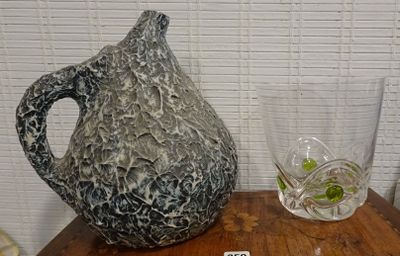 a vase and a glass on a table next to each other