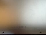 the back of a silver laptop computer sitting on top of a table