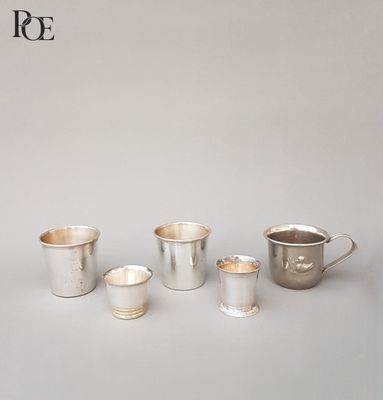 Plusieurs coupes en argent sont alignées sur une table