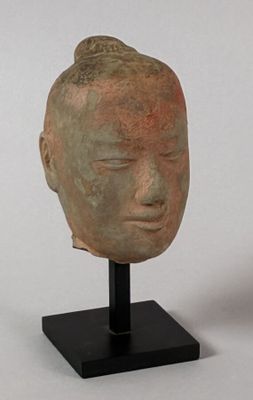 sculpture of a head on a black stand on a white background