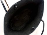 a black tote bag sitting on top of a metal stand