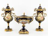 Deux vases munis d'anses et d'un couvercle sont posés sur une table.