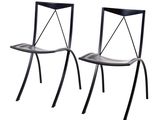 une paire de chaises de salle à manger en métal noir avec des assises en cuir noir