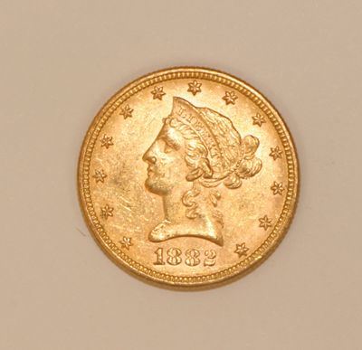 a close up of a gold coin with a woman ' s head on it