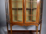 une vitrine ancienne avec des portes en verre et des étagères sur le dessus