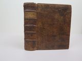 an old book sitting on top of a table next to a white wall