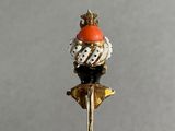 a gold stick with an orange and white hat on it