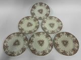 six assiettes marron et blanches ornées de motifs floraux sur fond blanc