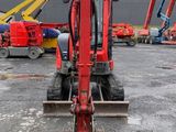 the back end of a red construction vehicle parked in a parking lot