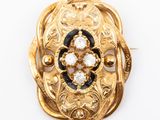 an image of a gold broochle with black and white stones
