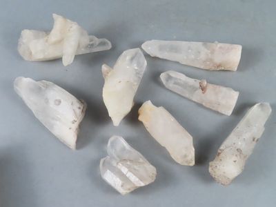 plusieurs morceaux de quartz blanc sur une surface grise
