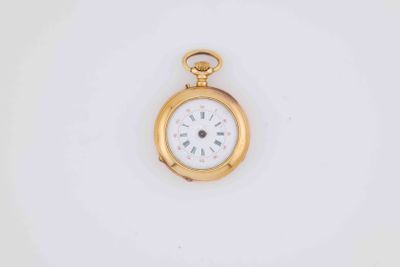 a close up of a gold pocket watch on a white surface