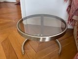 a coffee table with a glass top sitting on a wooden floor