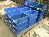 de nombreux bacs bleus empilés sur une palette dans un entrepôt