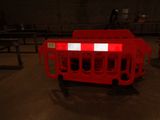 a red barricade with a white stripe on it in a dark room