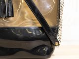 a black and gold purse with a tassel hanging from it