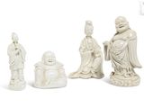 three white figurines of buddhas sitting on a white surface