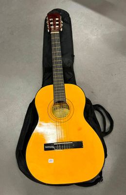une guitare orange avec un étui noir posée par terre
