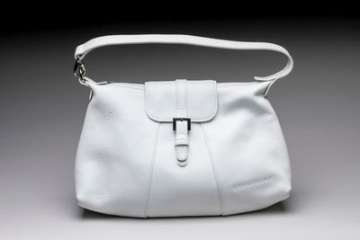 an image of a white purse on a gray background