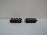 two toy trains sitting on a table next to each other