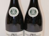 deux bouteilles de vin posées sur une table l'une à côté de l'autre