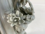 a statue of a woman holding a flower in her hand