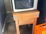 un micro-ondes posé sur une table à côté d'une caisse d'oranges