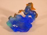 une figurine en verre bleu représentant une femme et un cheval