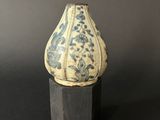 a blue and white vase sitting on a wooden stand