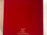 La boîte est rouge et porte une inscription dorée.