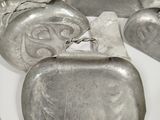 many silver purses on a white table with a knife