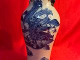 un vase bleu et blanc posé sur un tissu rouge