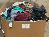 un carton rempli de vêtements posé sur le trottoir