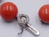a bracelet with a red bead and a silver clasp