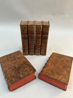 a set of four old books sitting on top of each other