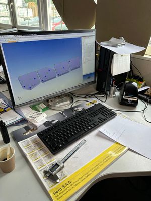 un bureau sur lequel se trouvent un ordinateur, un clavier, une souris et des papiers