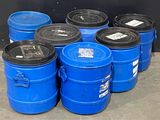 de nombreux fûts bleus avec des couvercles noirs posés par terre