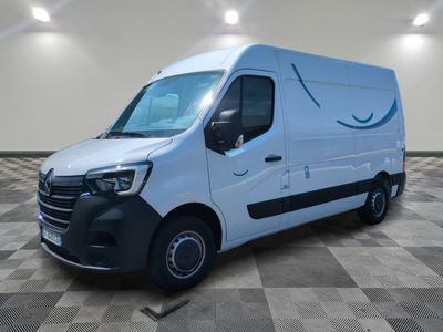 Une camionnette blanche est garée dans une grande pièce au sol carrelé.