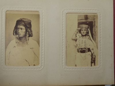 une vieille photo de deux femmes en costume traditionnel posant pour un cliché
