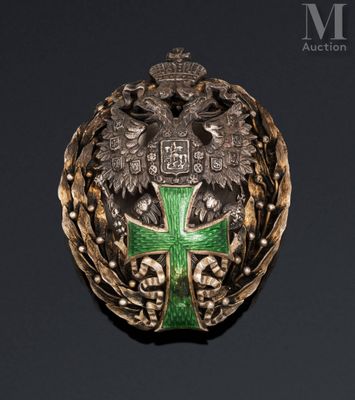a close up of a green and gold broochle with a cross on it
