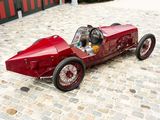 a red car that is sitting on a cobblestone street