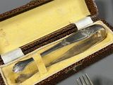 two forks and a knife in a box on a table